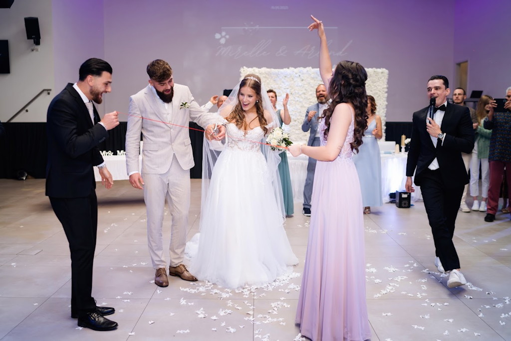Tamada leitet ein Spiel mit Brautpaar und G&auml;sten auf der Tanzfl&auml;che bei einer Hochzeit